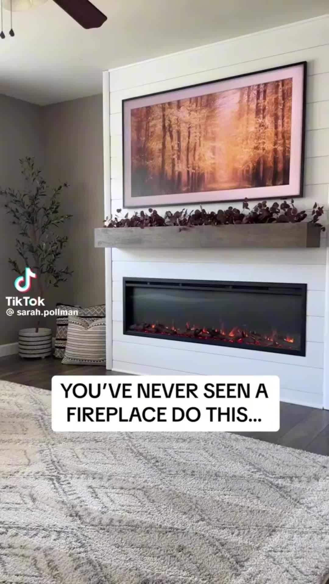 This may contain: a living room with a fire place in the middle and a painting on the wall above it that says, you've never seen a fireplace do this