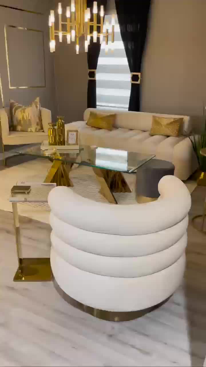 This may contain: a living room filled with white furniture and gold accents