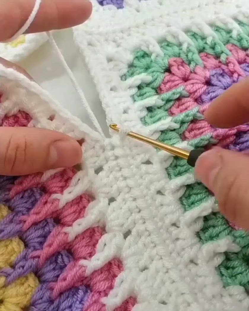 This may contain: someone is crocheting on the side of a blanket