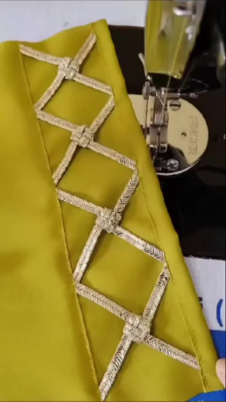 This may contain: the sewing machine is working on the yellow fabric that has been stitched together with silver thread