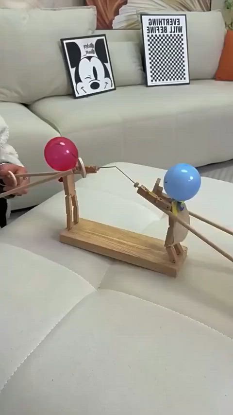 This may contain: a person is pulling two balloons on a wooden stand in front of a white couch