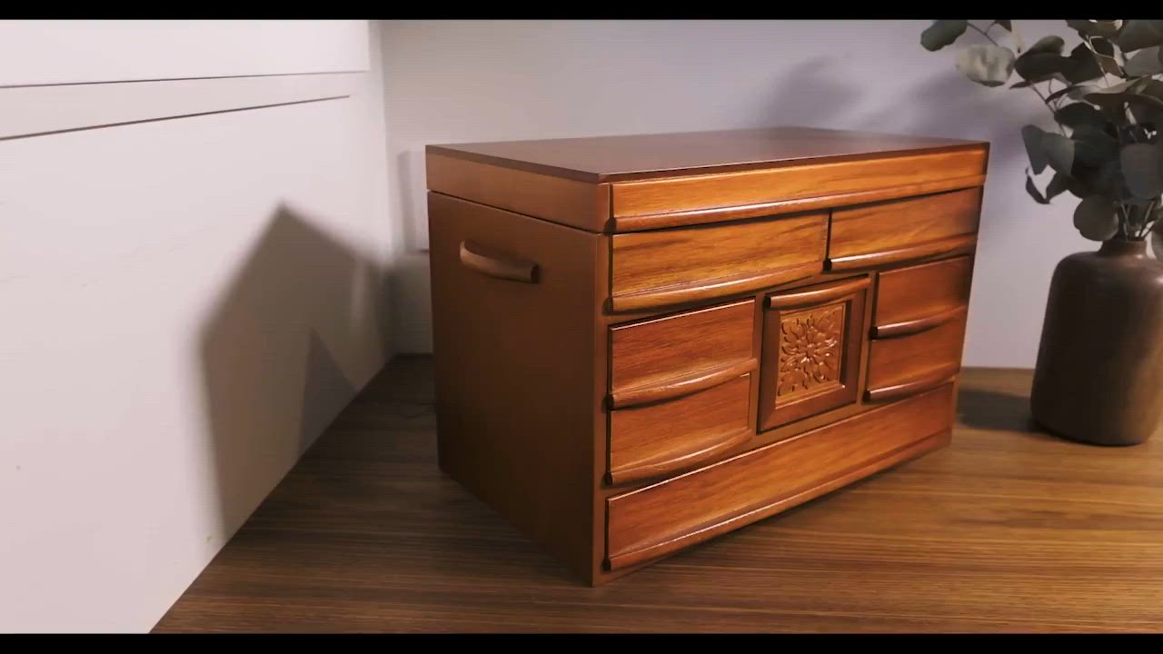 This may contain: a wooden cabinet sitting on top of a hard wood floor next to a potted plant