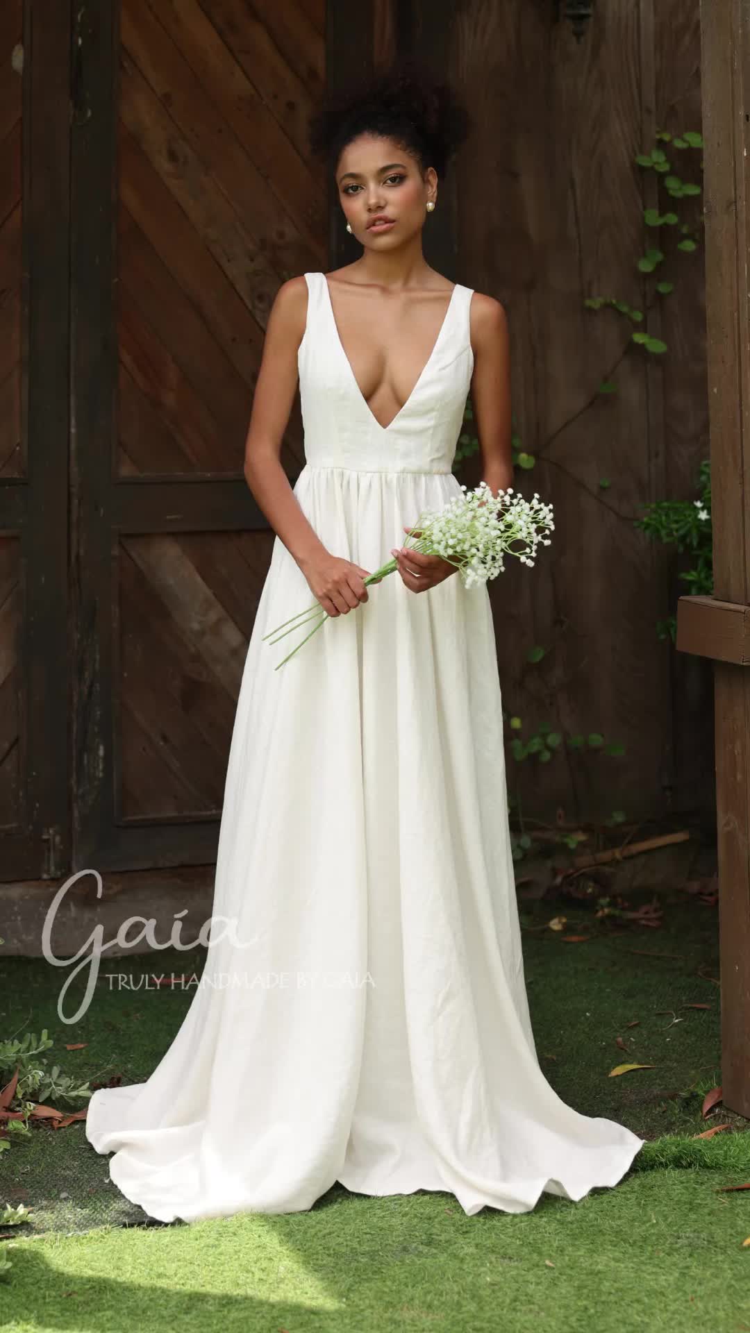 This may contain: a woman standing in front of a wooden wall wearing a white dress and holding flowers