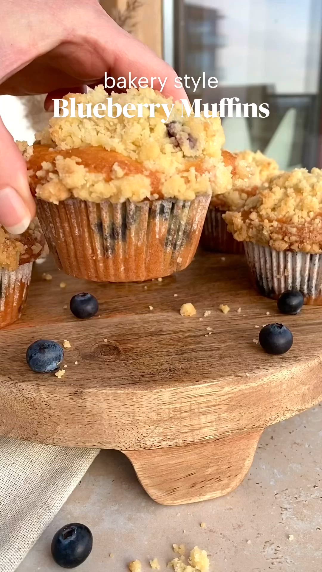 This may contain: blueberry muffins cut in half and being held by someone