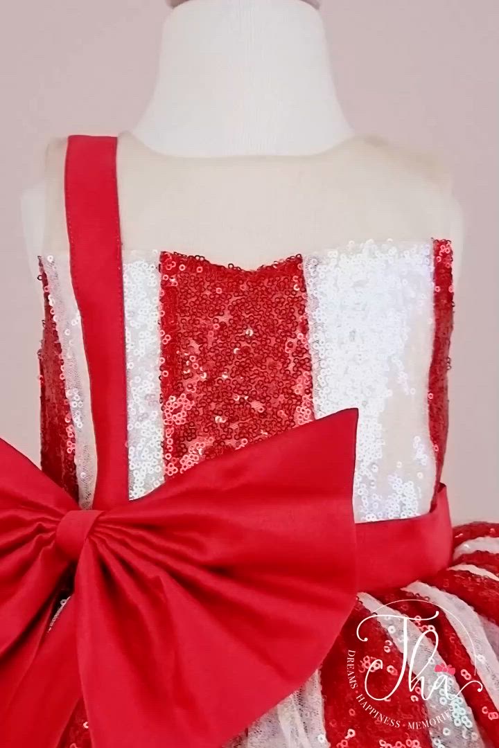 This contains: 360° view of a white and red Christmas dress. The dress has a lined red and white sequin top, a knee length red skirt, red ribbon. The skirt is made of layers of red tulle.