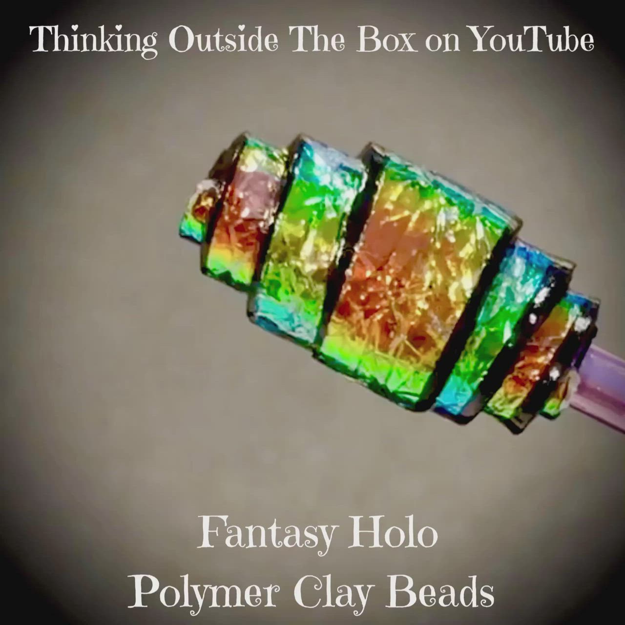 This may contain: a close up of a glass bead on a pink plastic tube with text reading thinking outside the box on youtube fantasy holo polymer clay beads