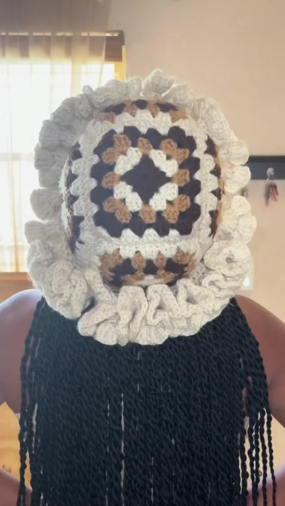 This may contain: the back of a woman's head wearing a crocheted hat