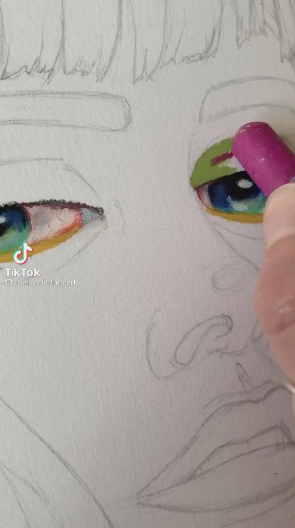 This may contain: someone is drawing something with colored pencils on the paper and it looks like they have eyes