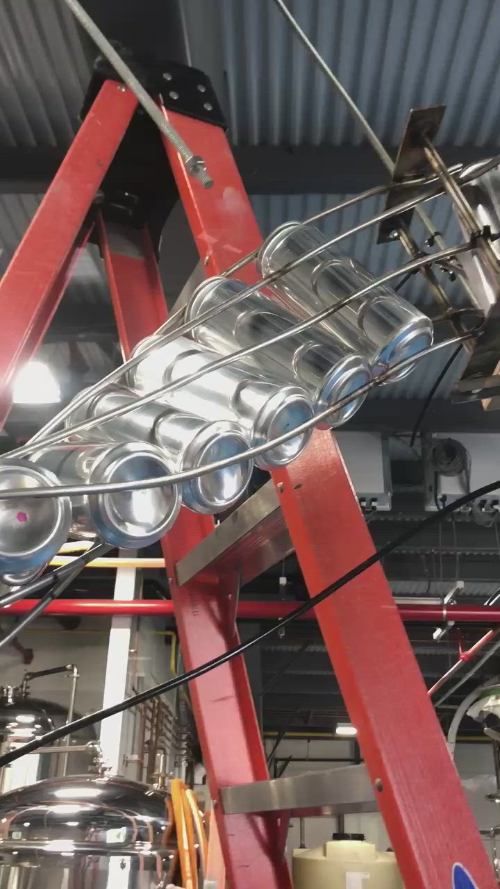 This may contain: an industrial kitchen with pots and pans hanging from the ceiling