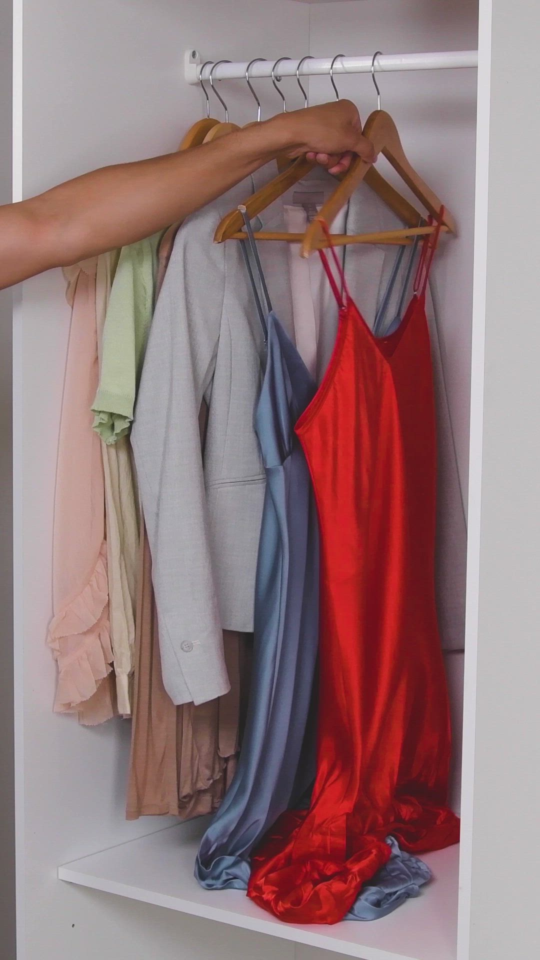 This may contain: an orange dress hanging on a closet with the words closet organization how to hang your clothes