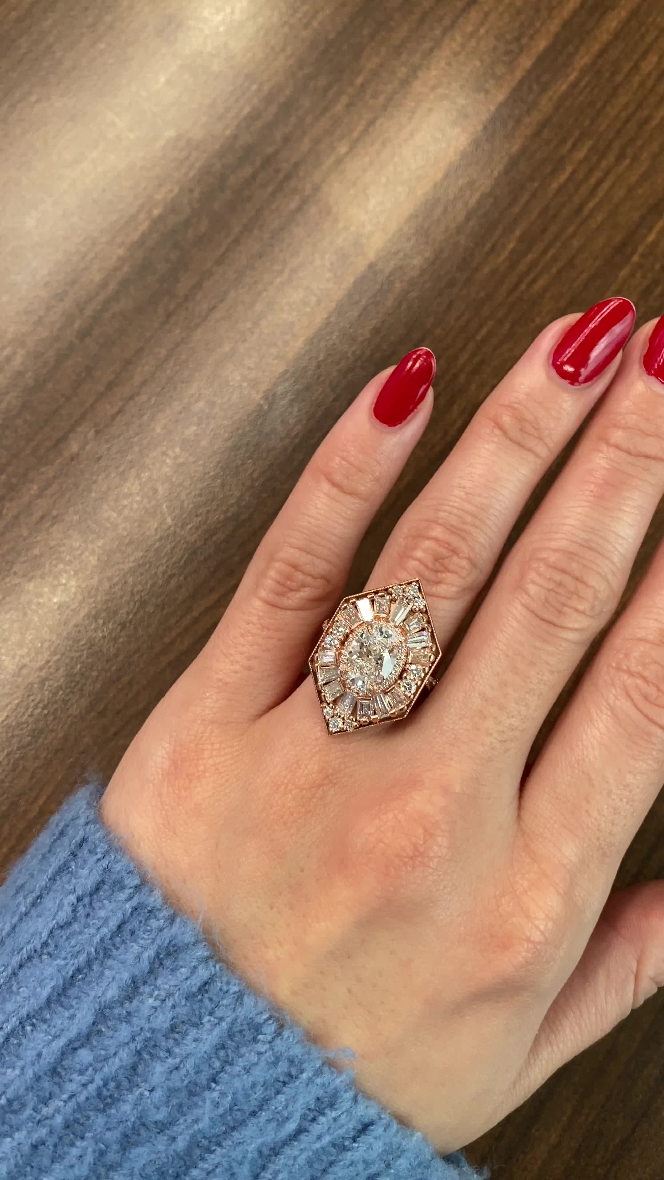 This may contain: a woman's hand with red nails and a ring on it