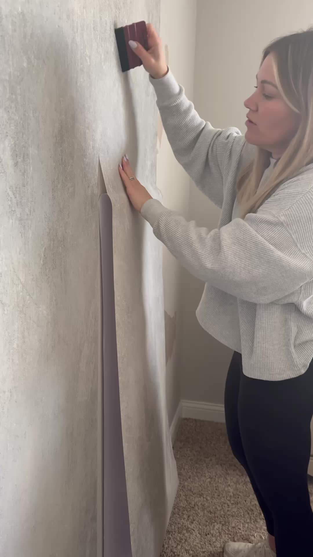 This may contain: a woman is painting a wall with white paint