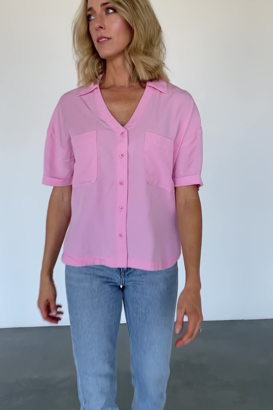 FINAL SALE Perfect casual and comfortable top Soft woven material with great flow Soft French Pink color Collared style with extended placard Button down with matching buttons Patch pockets on front bust Center-back dart detail Dropped shoulder Single-cuffed short sleeve Loose, slightly cropped fit Rounded shirt-tail hem with vents on both sides Trina is 5'6, cup size 32D, size 2 and is wearing size S