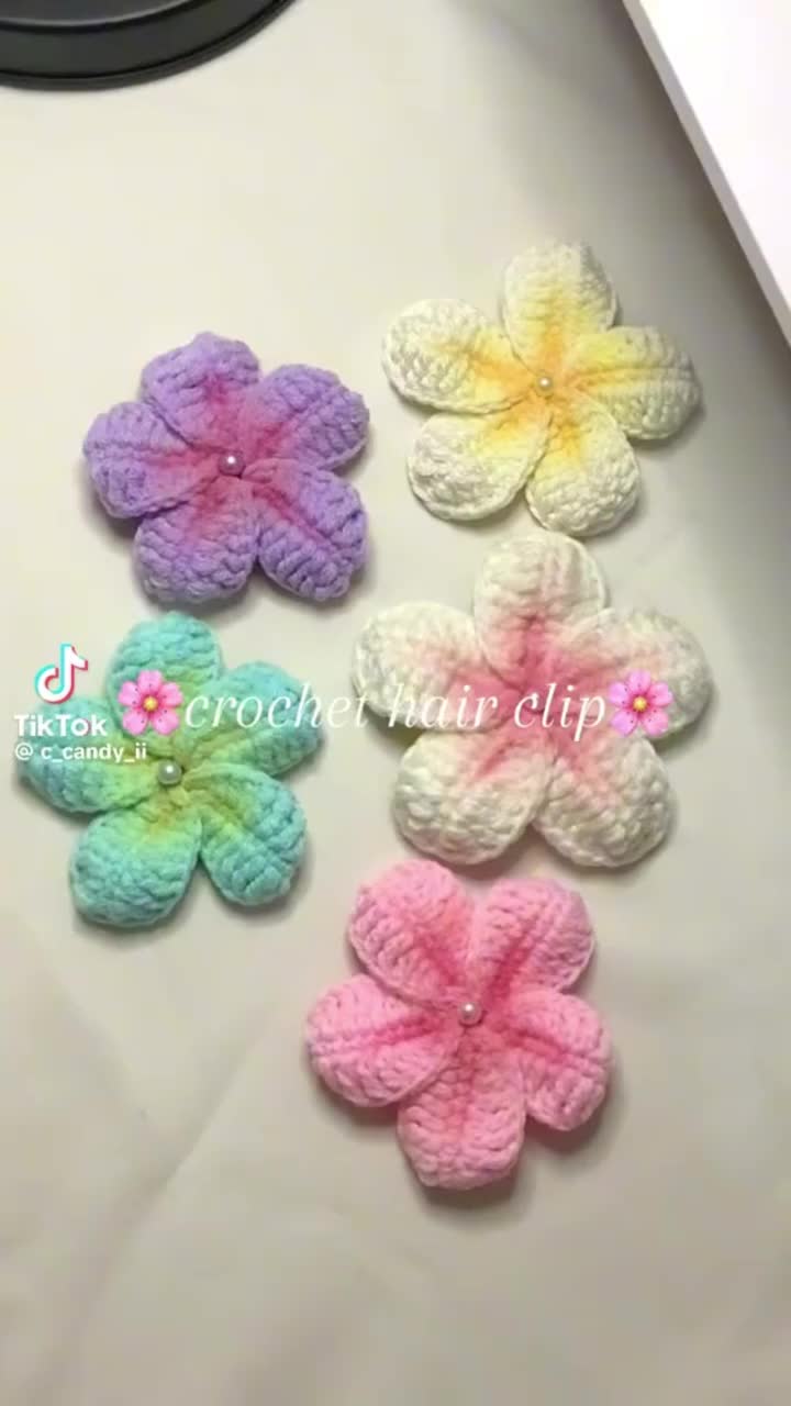 This may contain: six crocheted flowers sitting on top of a white table next to a mirror