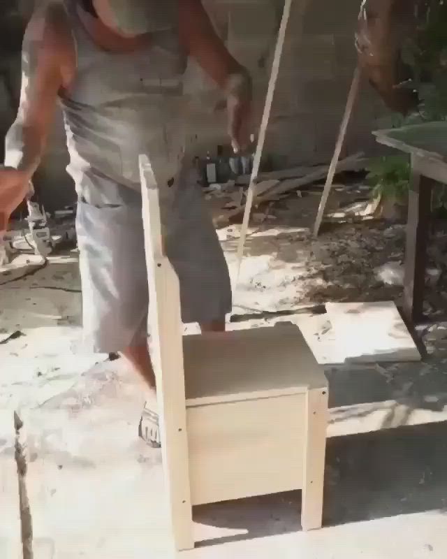 This may contain: a man standing next to a wooden chair