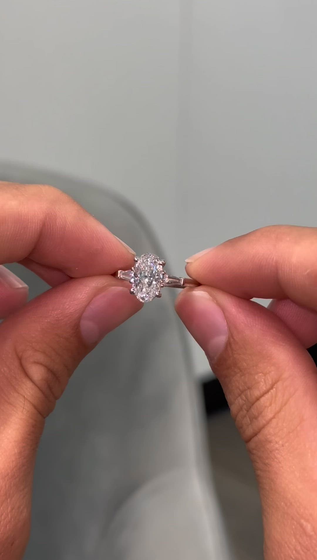 This may contain: a person holding a diamond ring in their hand