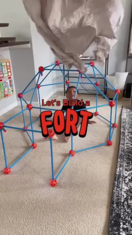 This may contain: a kid is playing with a fort in the living room and it looks like he's building a fort