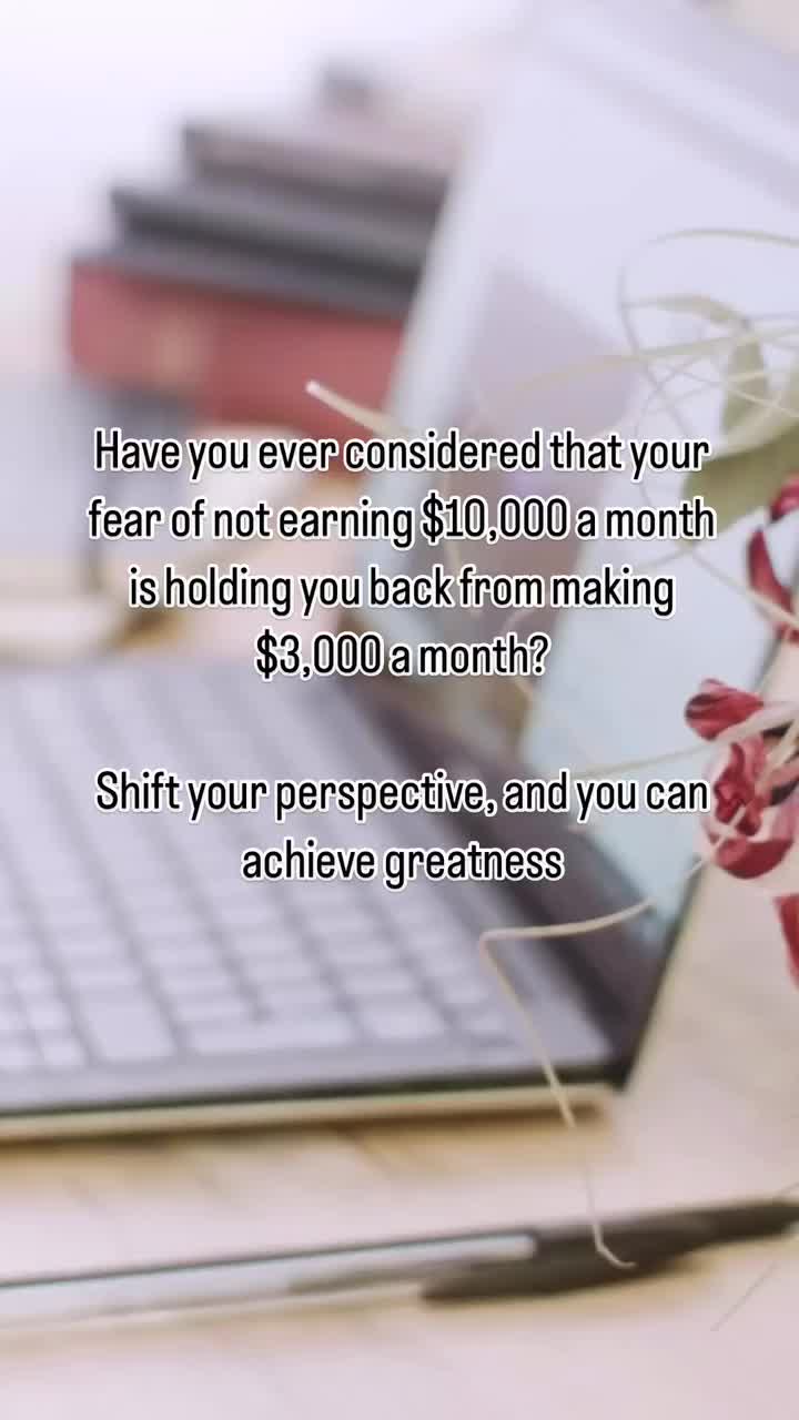 This may contain: a laptop computer sitting on top of a wooden desk next to a pen and flower