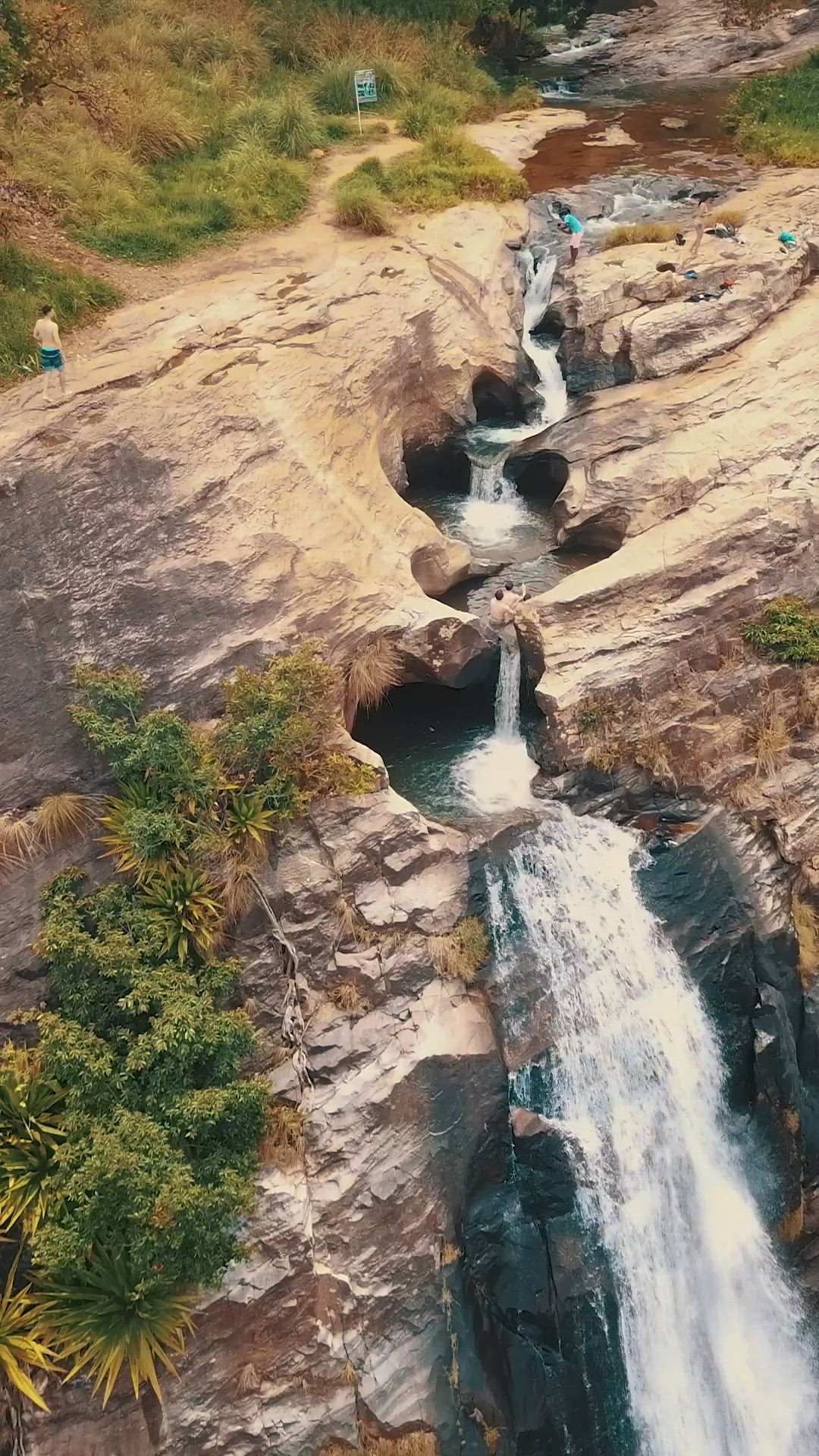 This may contain: people are standing at the top of a waterfall and looking down on it from above