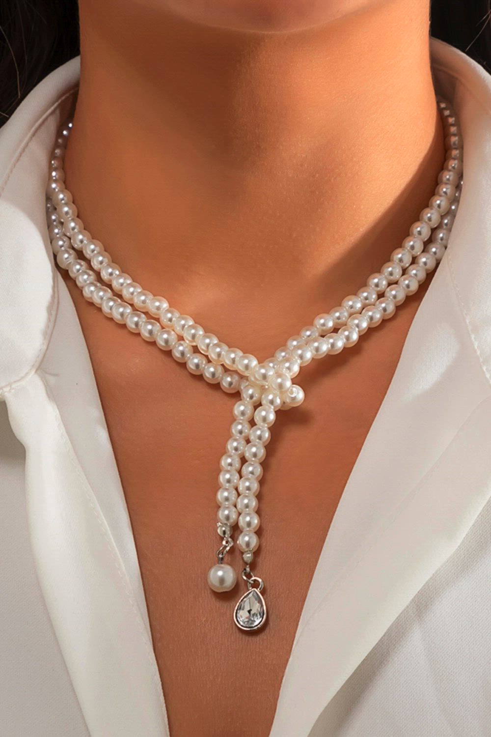 This contains: This vintage-inspired necklace features an elegant imitation-pearl heart pendant with a delicate OT buckle design. Perfect for weddings and special occasions, it adds a touch of sophistication to any outfit. Adorned with a bead chain, this necklace is a must-have accessory for any woman's jewelry collection.