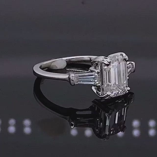 This may contain: an emerald cut diamond ring with baguettes on the sides