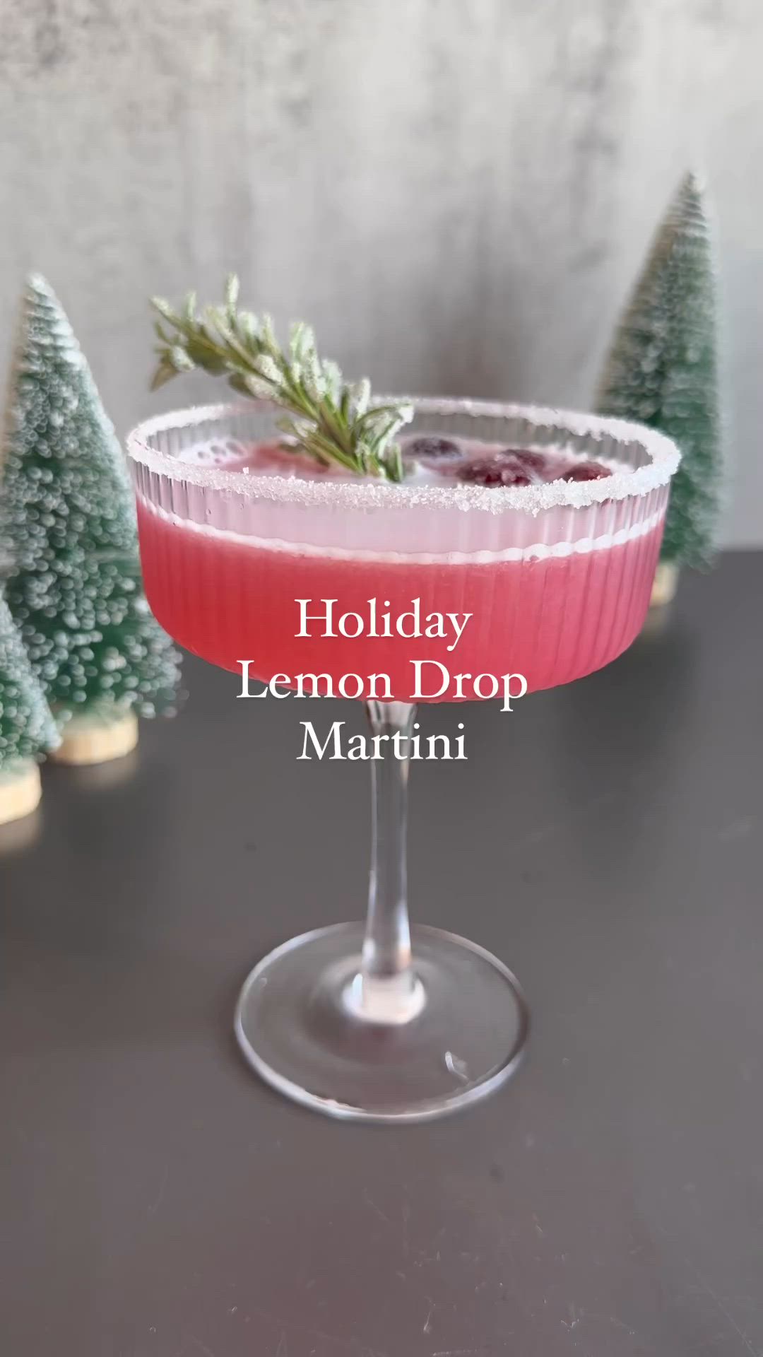 This may contain: a holiday lemon drop martini with cranberry sauce and rosemary garnish on the rim