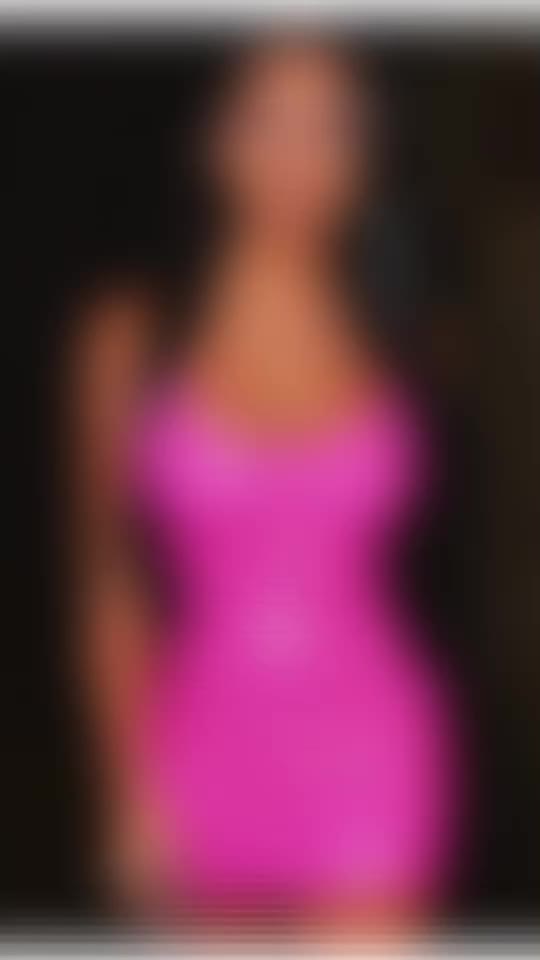 This may contain: a blurry image of a woman in a pink dress with her hand on her hip