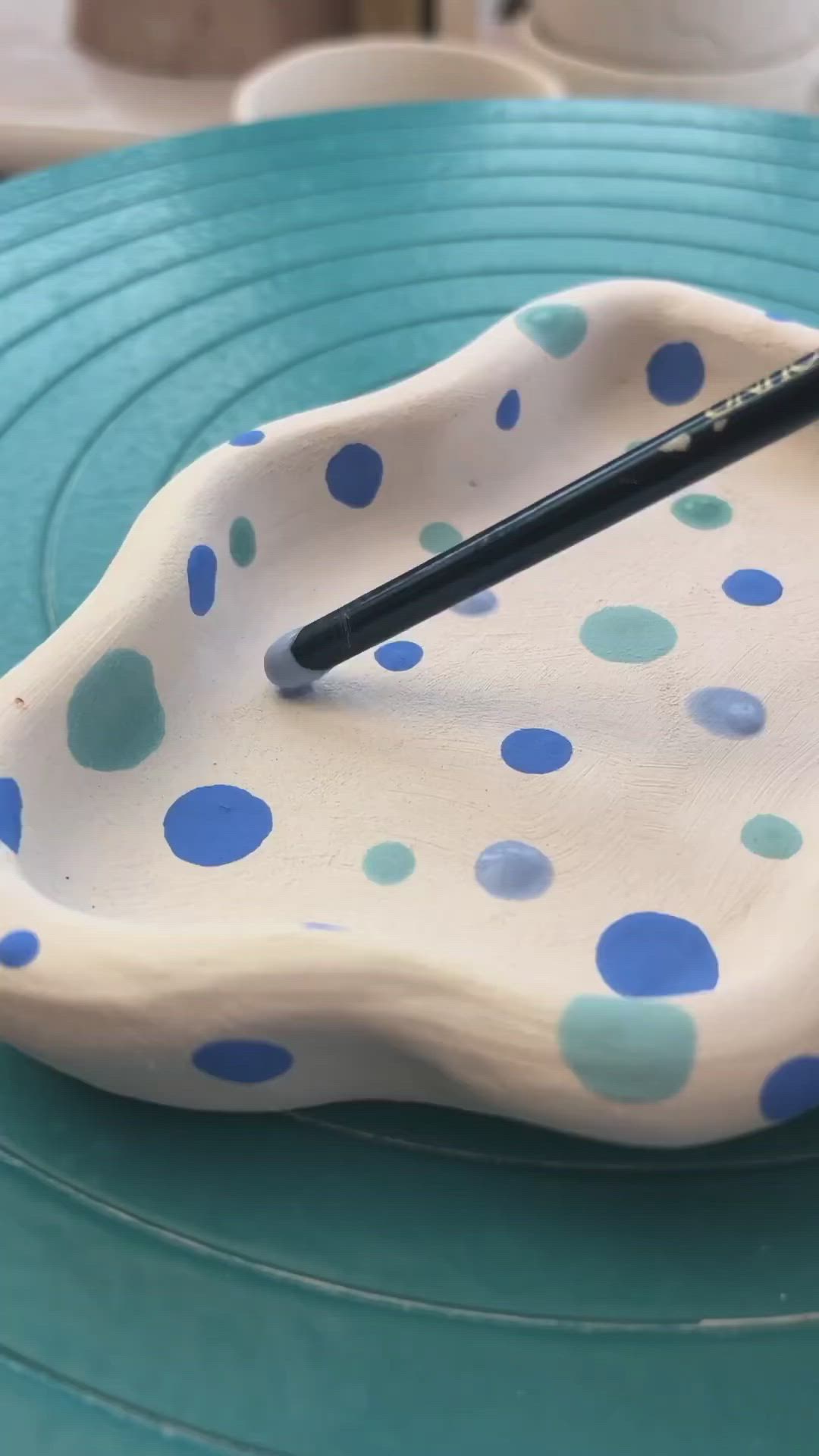 This may contain: a blue and white polka dot paper plate with a black marker on it, sitting on a table