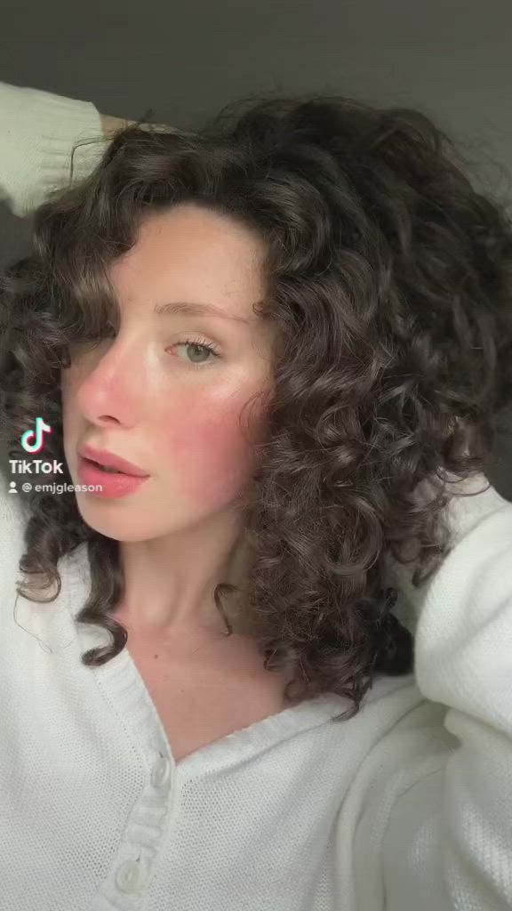 This contains: Girl with curly hair showing her routine on tik tok