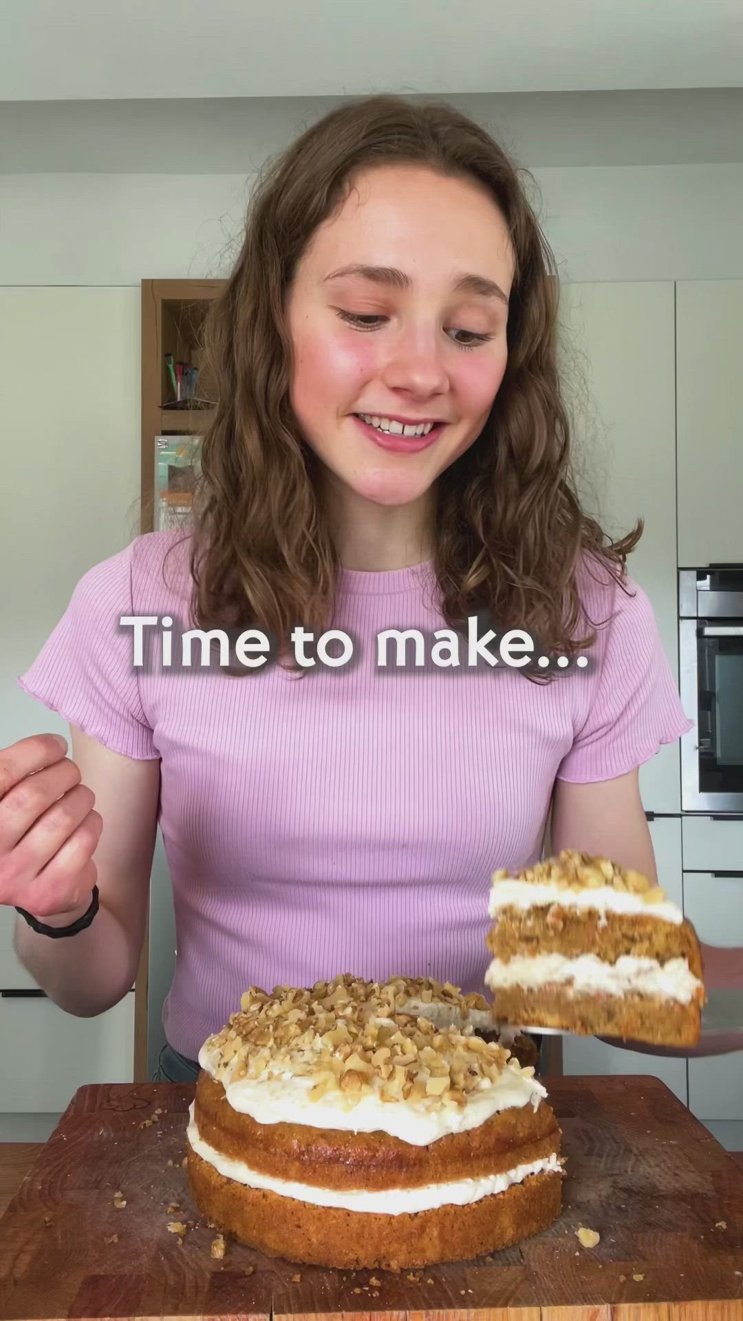 This may contain: a woman holding a piece of cake with the words vegan carrot cake on it