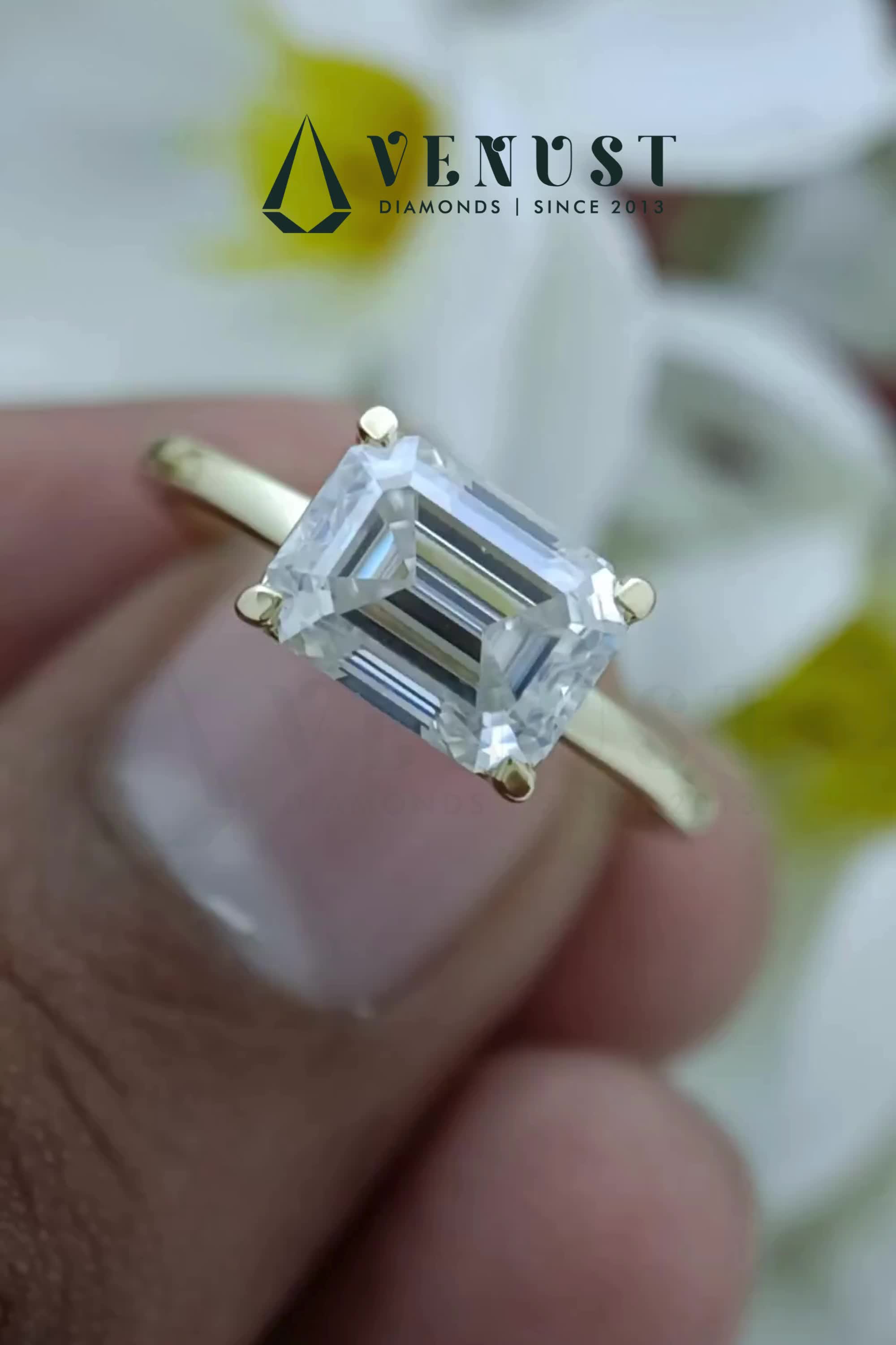 This stunning Emerald Cut East West Solitaire Diamond Engagement Ring is a modern twist on a classic design. Set horizontally, the exquisite diamond sparkles brilliantly, making it a unique and captivating choice for your proposal. Perfect for the one who appreciates elegance and style.  Customize your diamond ring by contacting us at questions@venustdiamonds.com. #emeraldcutengagementring #solitaireengagementring #eastwestengagementring #uniqueengagementring #futureengagementring #moissaniteengagementring #finejewelry #edgyengagementring #christmasproposalring #christmasjewelry #halloweendiamondjewelry  #halloweendiamondring #diamondrings #goldring #ringsaesthetic #diamondringdesigns #customengagementring #proposaldiamondring