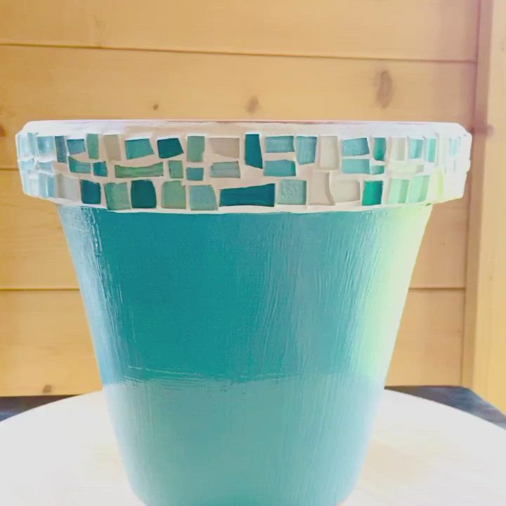 This may contain: a blue vase sitting on top of a white table