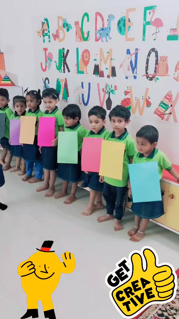 This may contain: a group of children holding up signs in front of a wall with letters on it