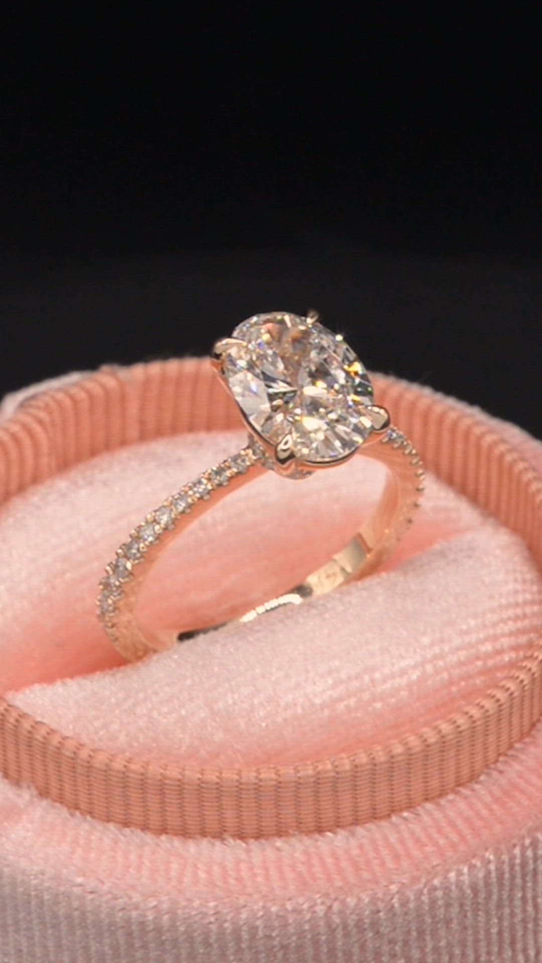 This may contain: an engagement ring sitting on top of a pink velvet box with a diamond in it