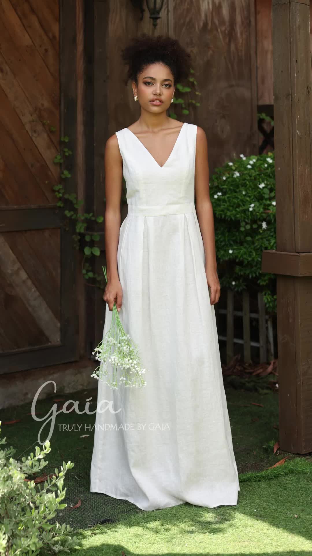 This may contain: a woman in a white dress holding a flower bouquet and posing for a photo outside