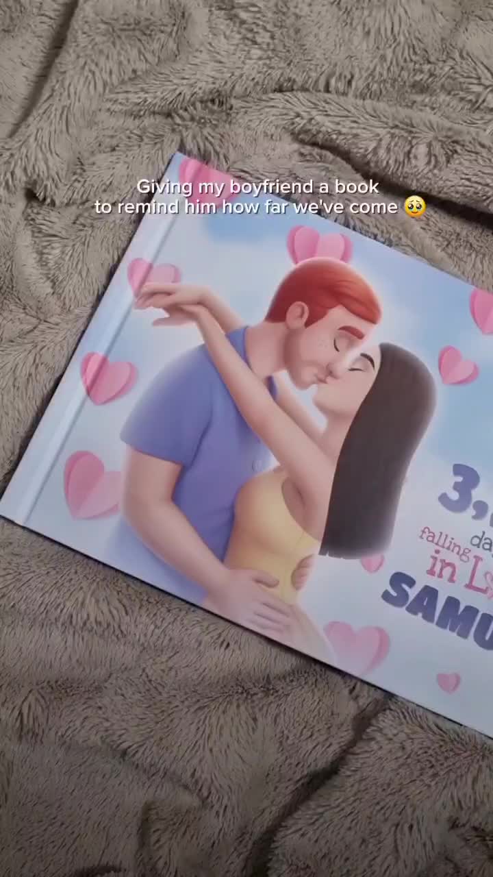 This may contain: an open book with the cover pulled back to show a cartoon character hugging a woman's face