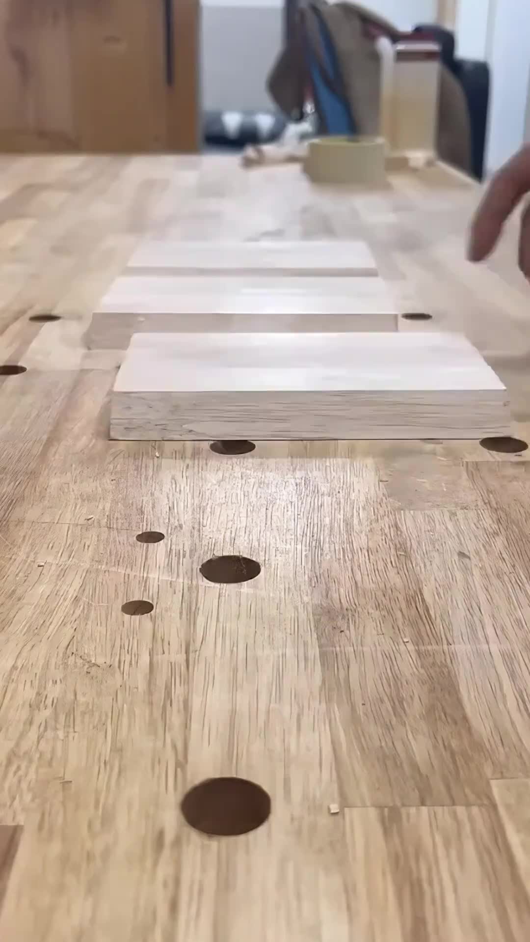 This may contain: a person is working with wood in a woodenworking shop, while another hand reaches for the box