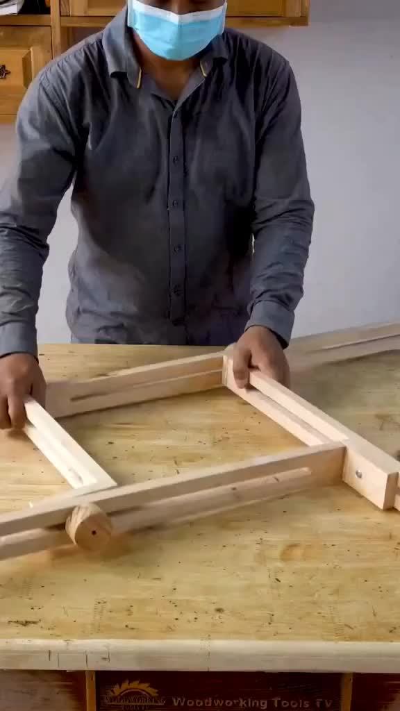 This may contain: a man wearing a face mask is making wooden frames