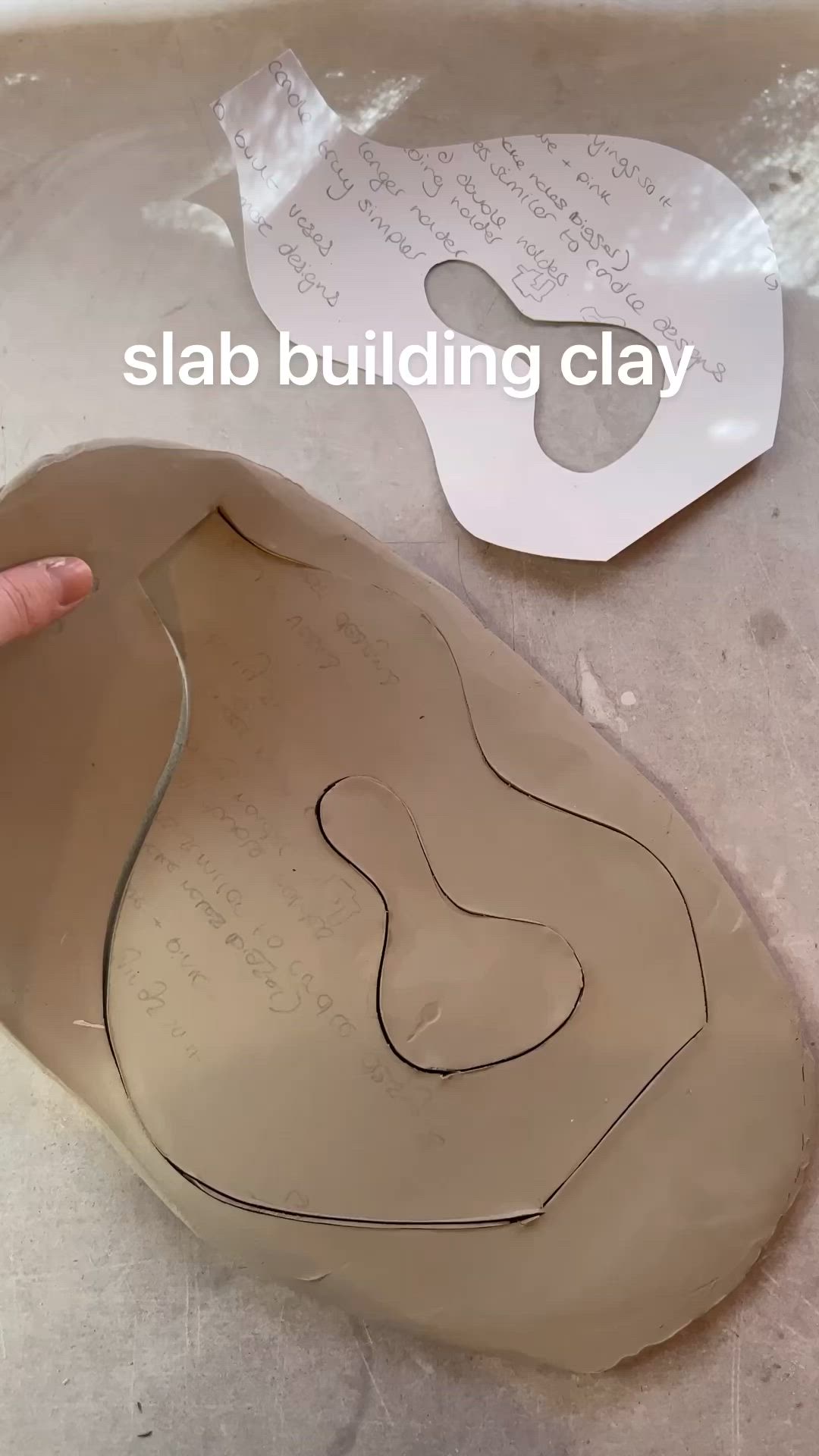 This may contain: a hand is pointing at the side of a clay sculpture that has been made into a shape