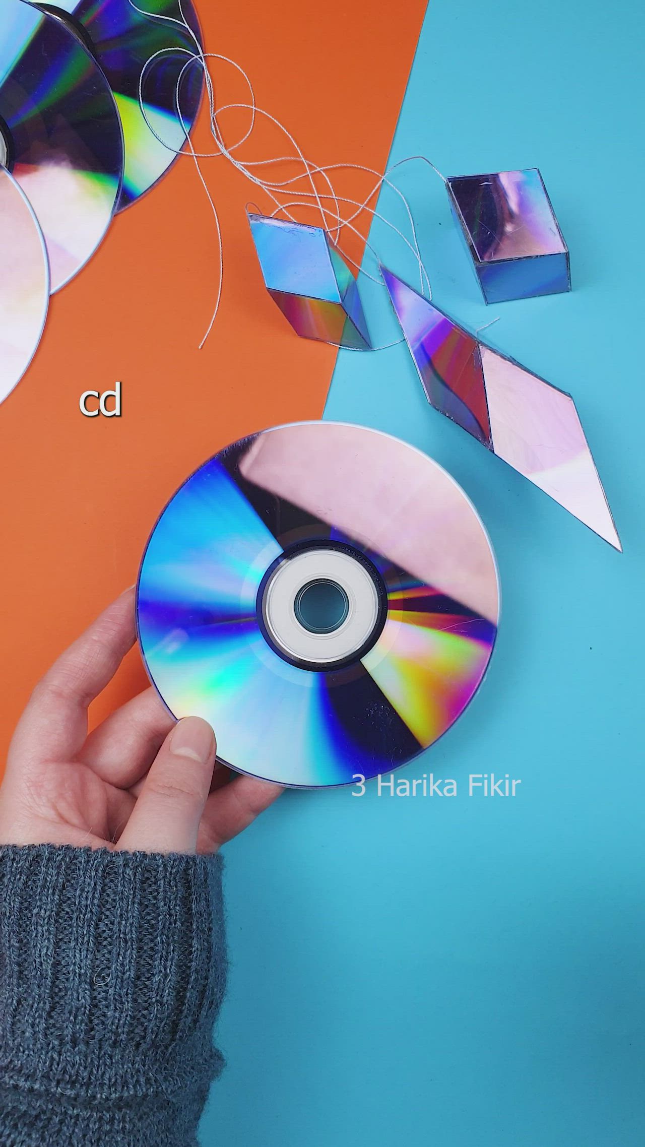 This may contain: a person is holding two cds in their hands, with the cd being held up