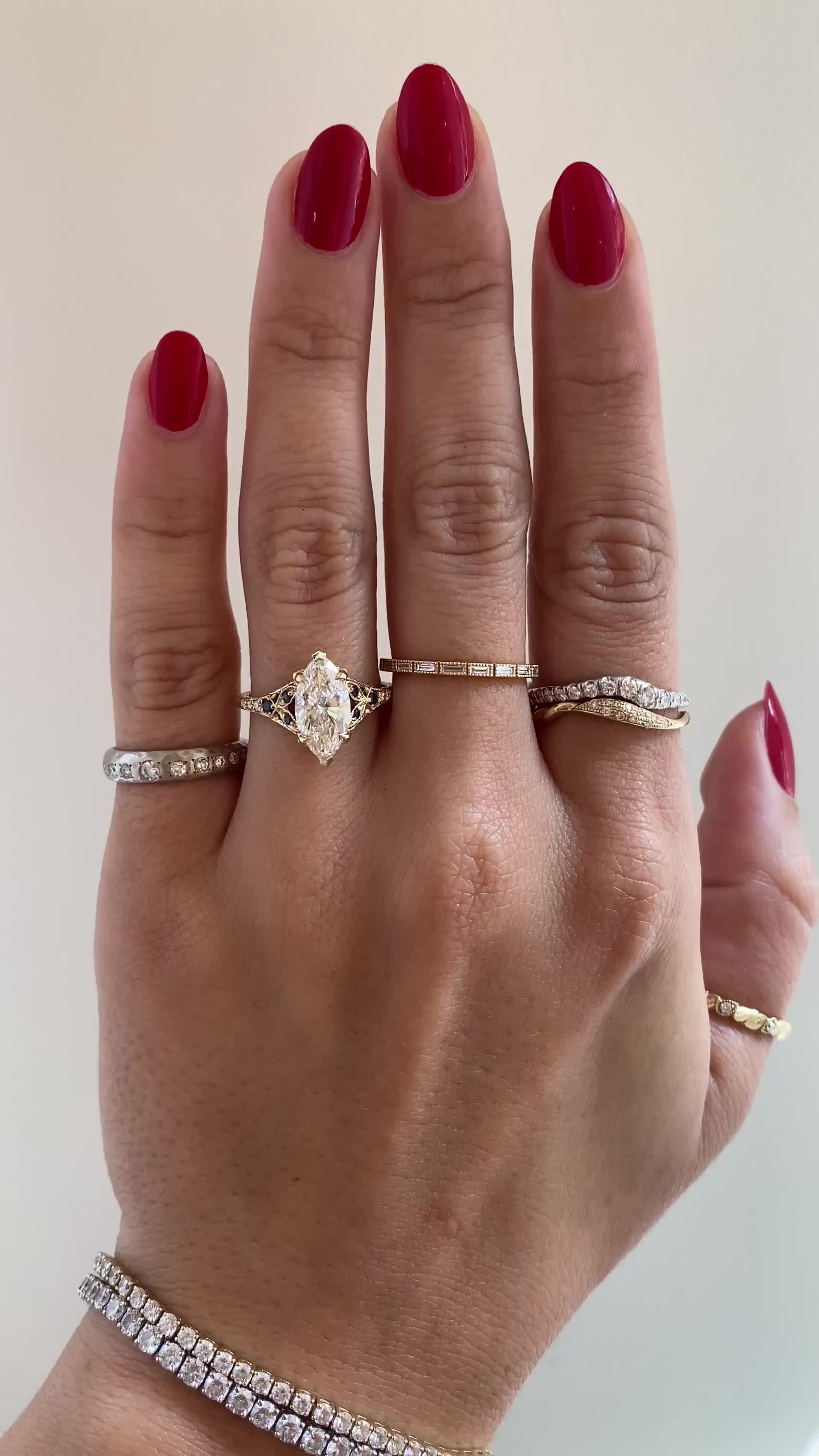 This may contain: a woman's hand with three different rings on it and one ring has a diamond in the middle