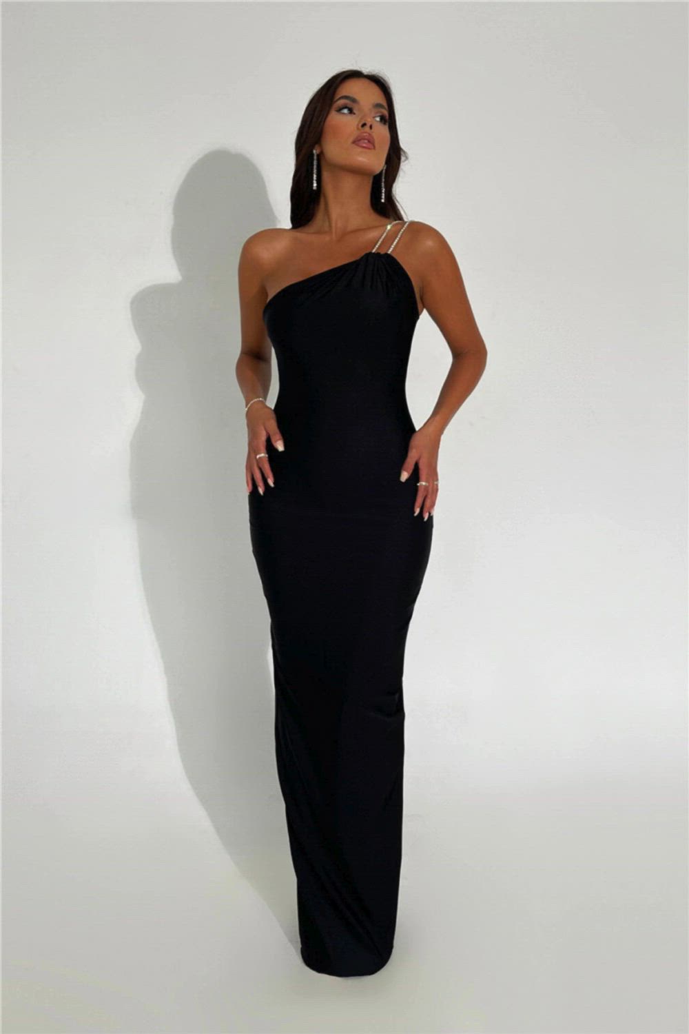 This contains: This one shoulder backless maxi dress is the perfect addition to your wardrobe for any special occasion. With its sexy off-shoulder design and bodycon fit, it's sure to turn heads. Made from high-quality materials, it offers both comfort and style. Elevate your look and feel confident in this fashion-forward gown.