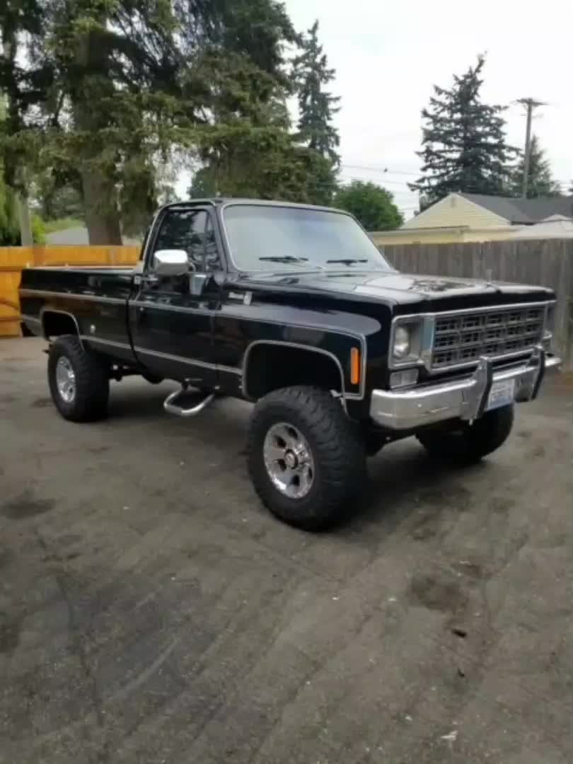 This may contain: a black pickup truck parked in a driveway