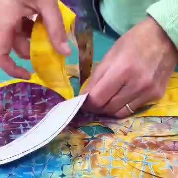 This may contain: a woman is working on a colorful quilt