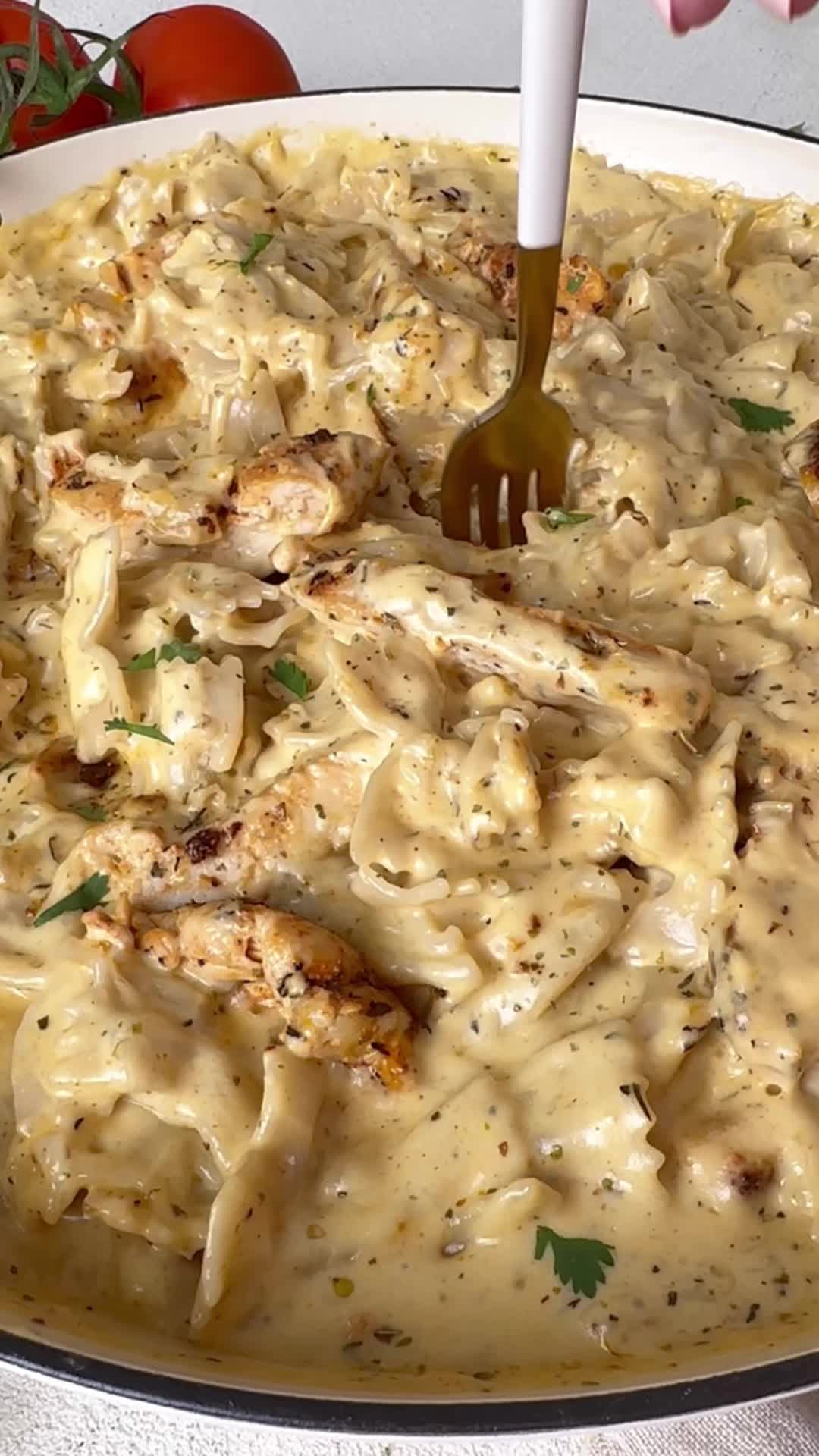 This may contain: a person is holding a fork in a bowl of chicken and pasta casserole