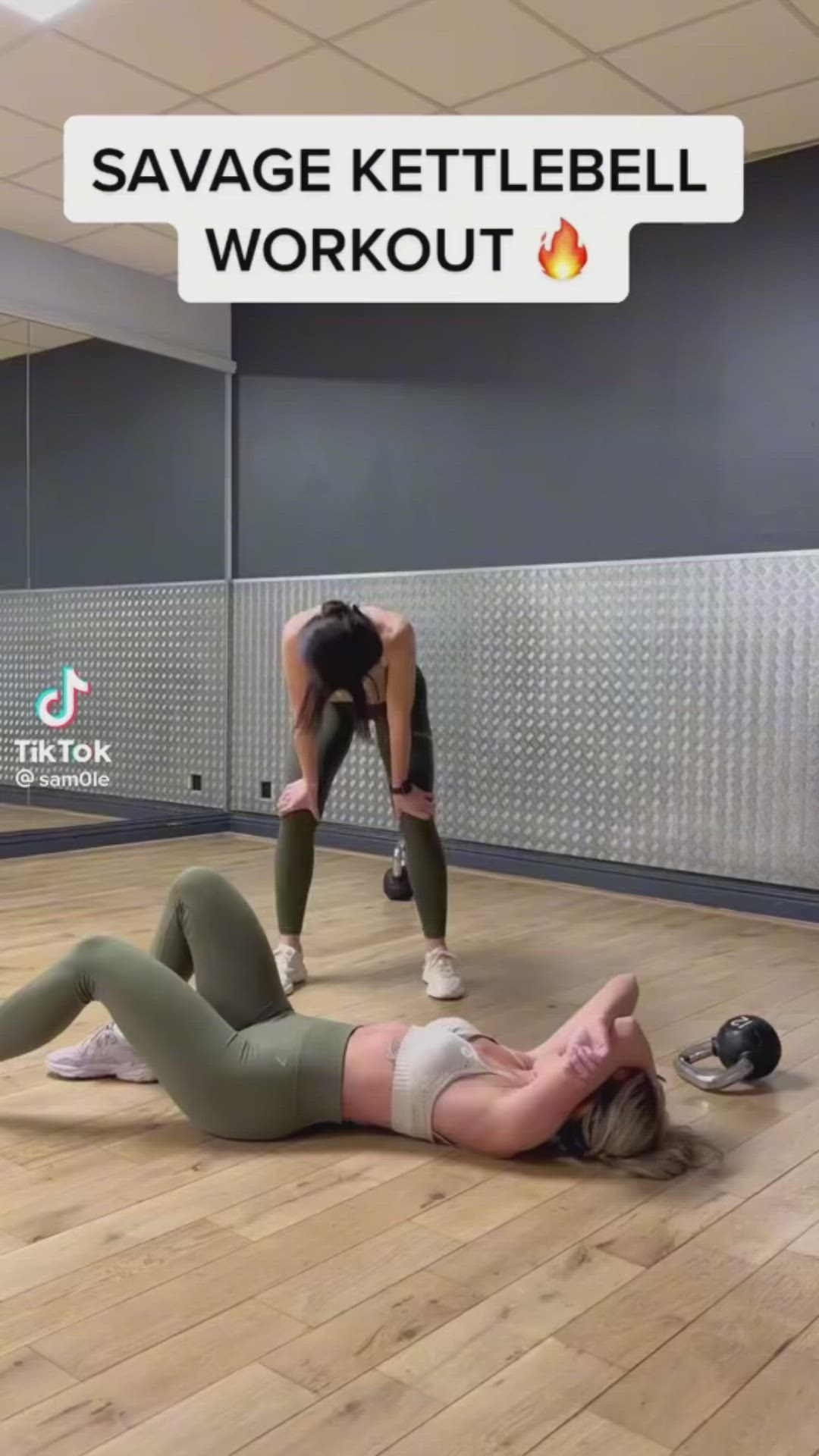 This may contain: two women doing exercises on the floor in an empty room with a sign that says, savge kettlebell workout