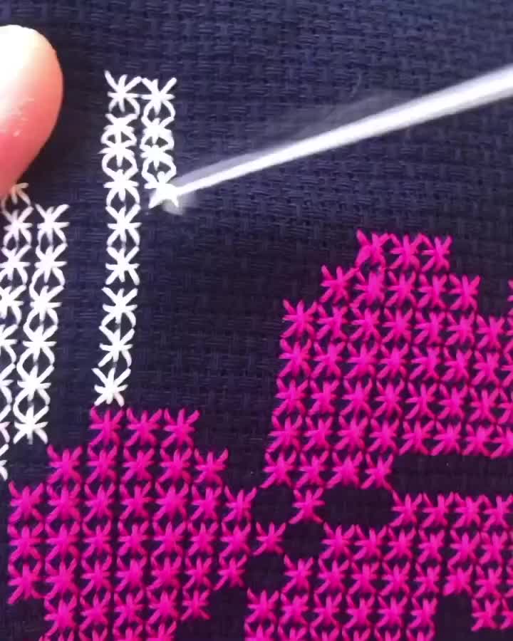 This may contain: someone is stitching flowers on a t - shirt with pink and white trims