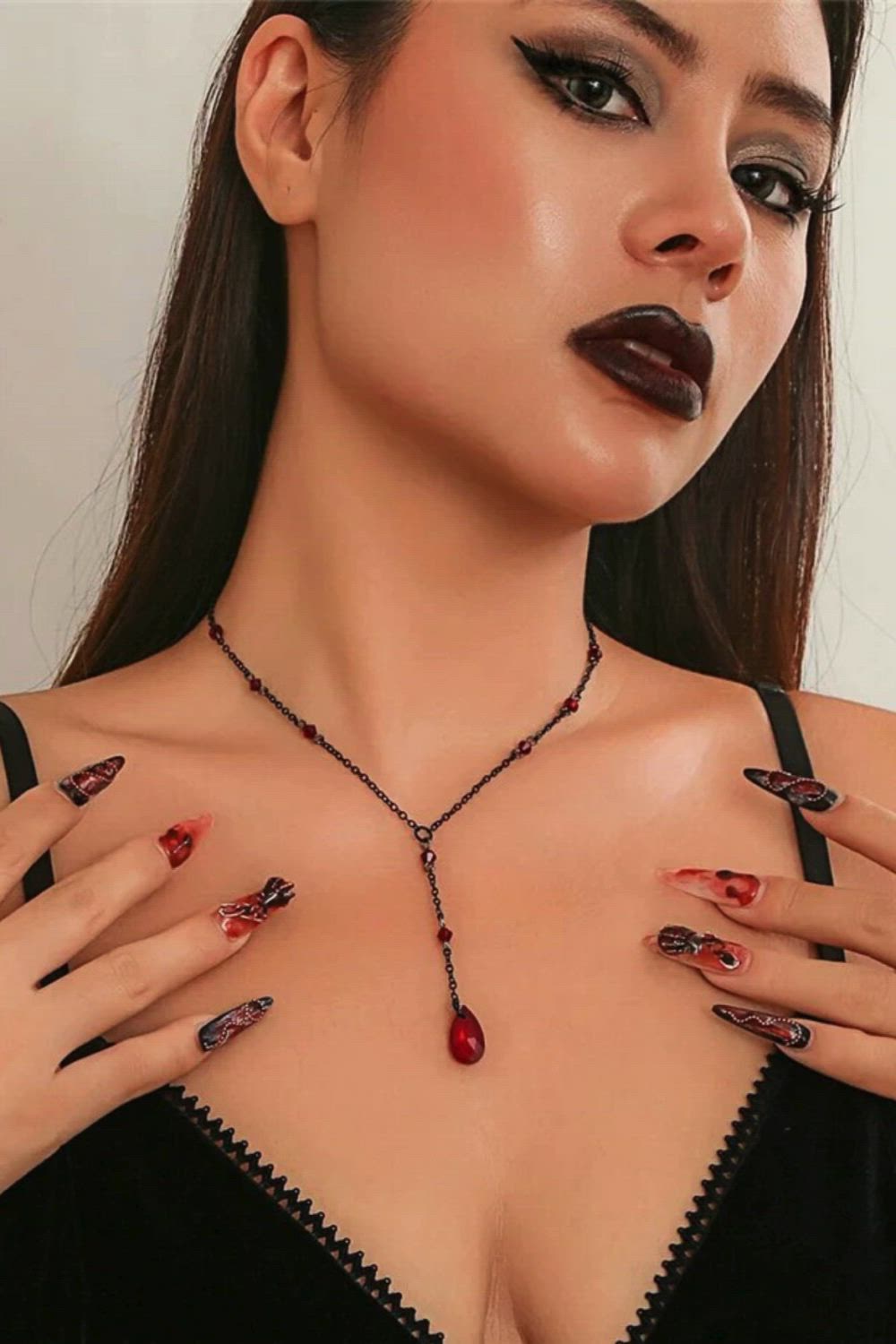 This contains: This elegant Black Water Drop Crystal Chest Chain Necklace is a must-have accessory for any woman. The vintage design and sexy link choker add a touch of sophistication to any outfit. Perfect for Halloween, this necklace will make you stand out in any crowd. Get your Y2K style on with this stunning piece of jewelry.