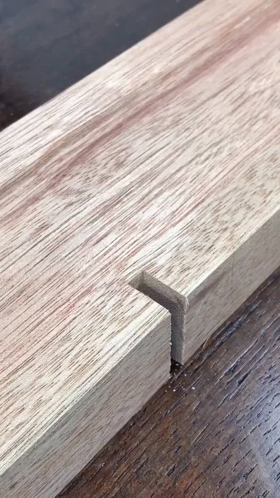 This may contain: a person using a nail to attach a piece of wood