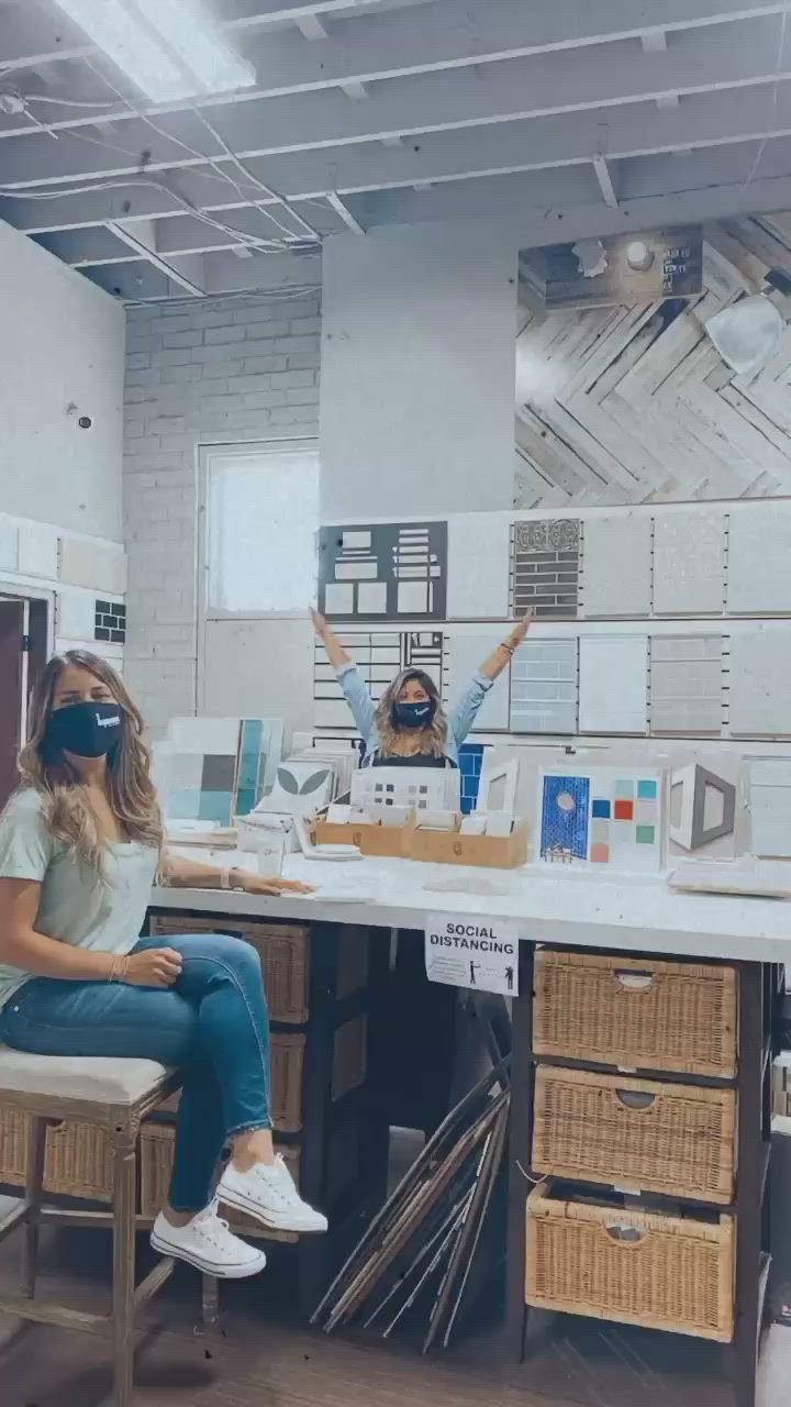 This may contain: two women wearing masks sitting at a desk